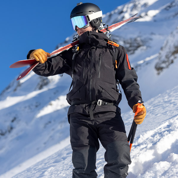 Man standing with ski in The Mountain Studio ski wear in Vail